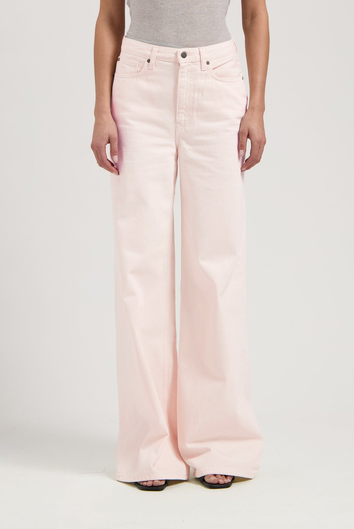 High-waisted, wide-leg light pink denim jeans paired with a gray sleeveless top, showcasing a minimalist fashion style.