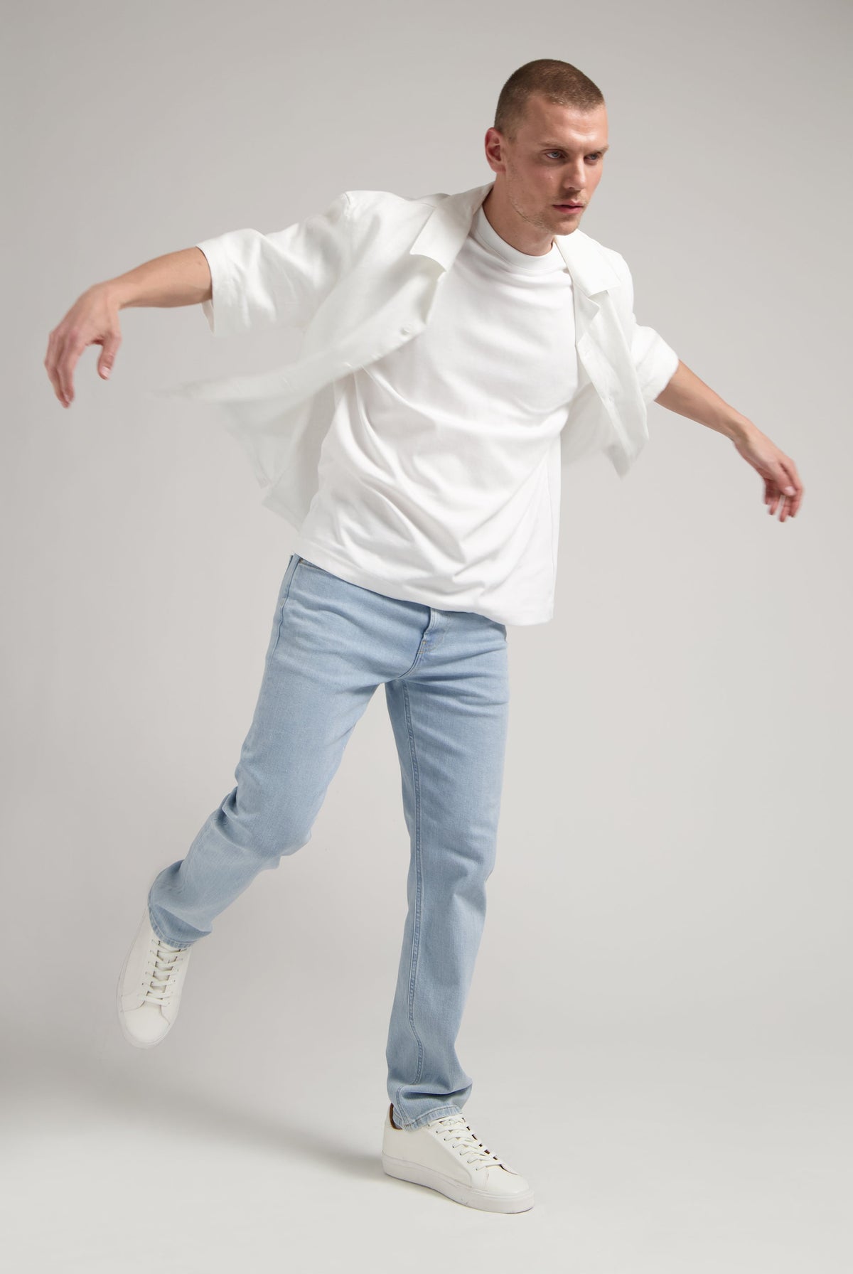 Sustainable MUD Jeans in deep blue denim, crafted for an ethical wardrobe, shown with white sneakers.