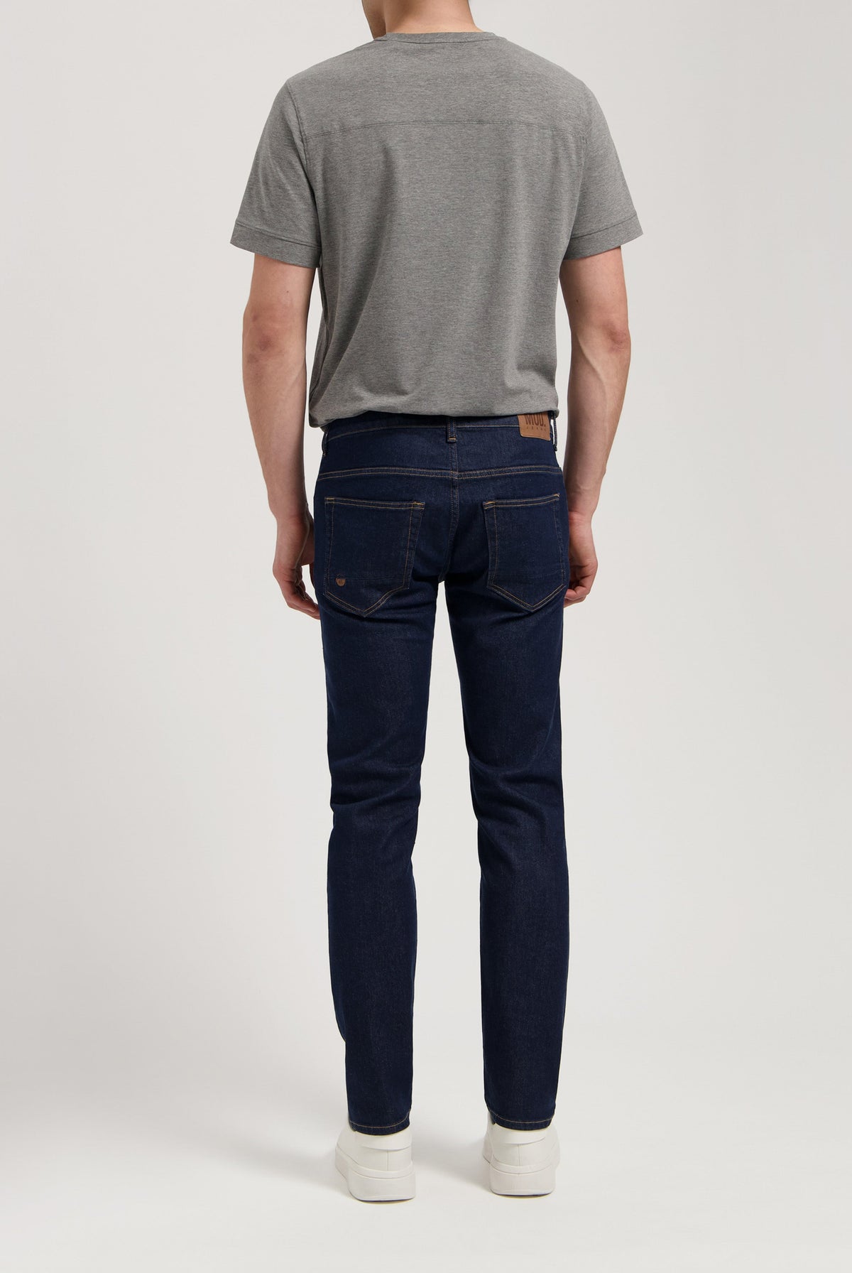 Sustainable MUD Jeans made from organic cotton, styled with a gray sweater, offering a timeless and ethical fashion choice.