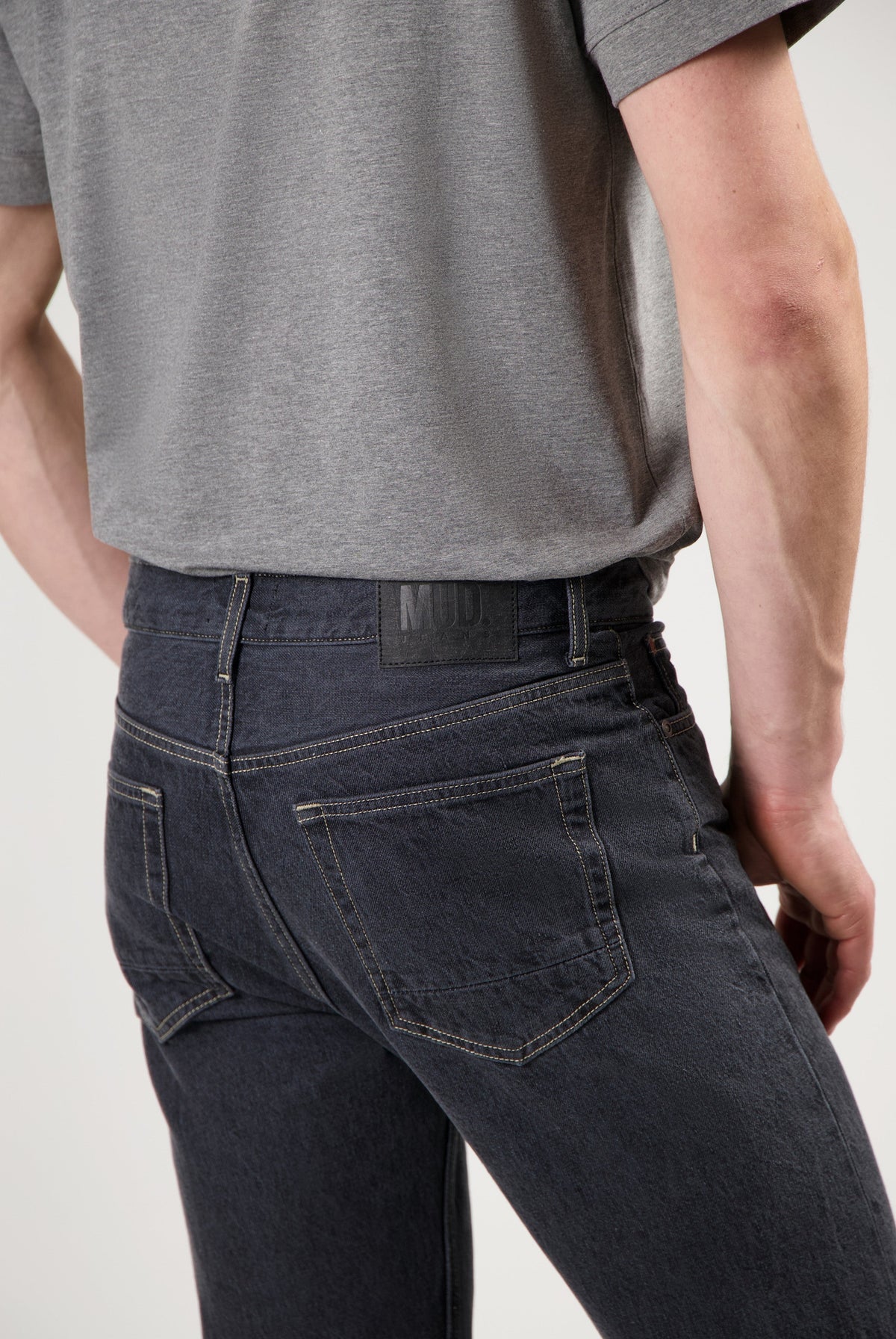 Sustainable black MUD Jeans crafted from organic cotton, paired with a cozy white sweater for ethical fashion style.