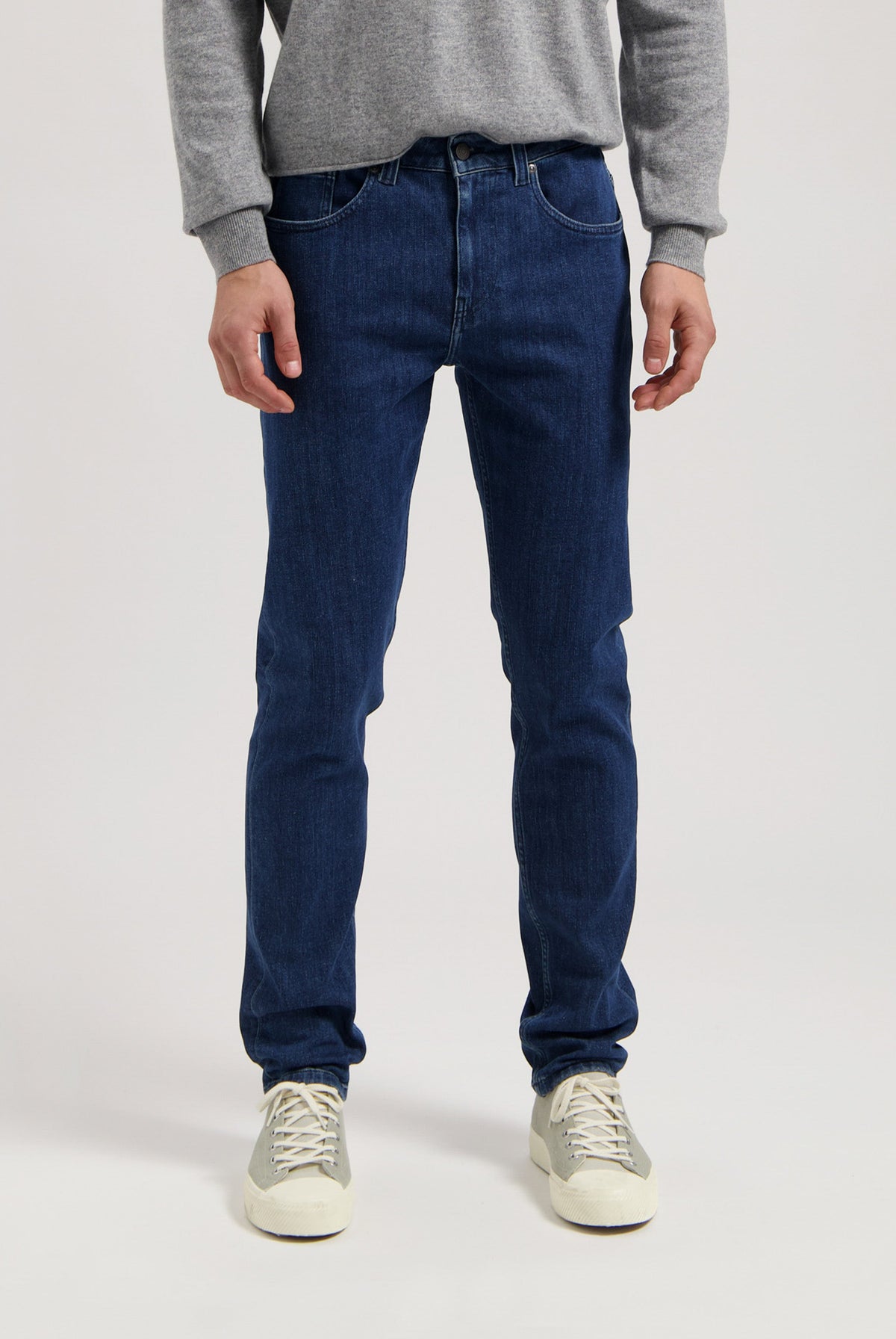Sustainable MUD Jeans in dark denim, styled with white tops for an ethical fashion look, perfect for casual wear.
