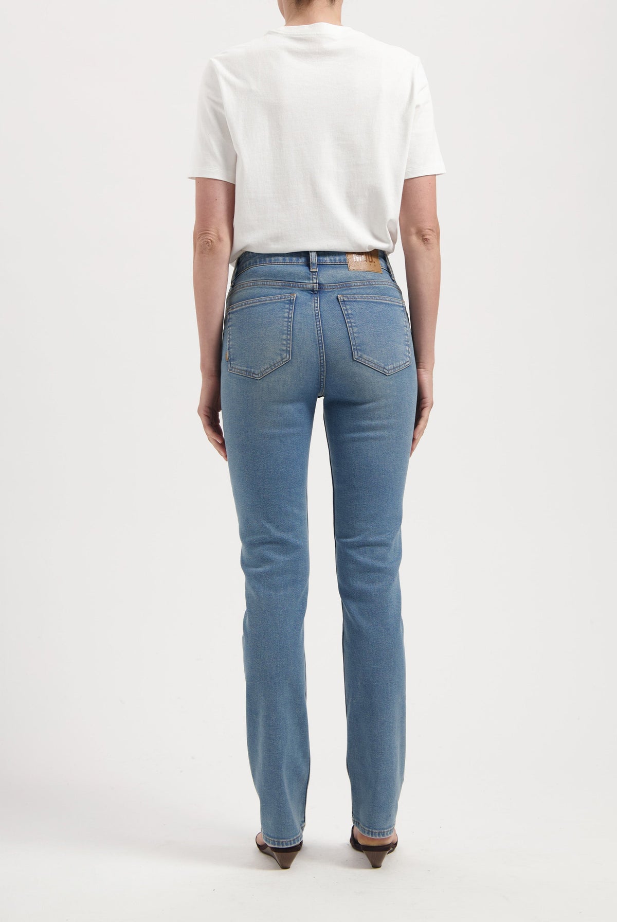 Classic straight-cut blue jeans with a white cotton t-shirt, showcasing back view of denim detailing and slim fit.
