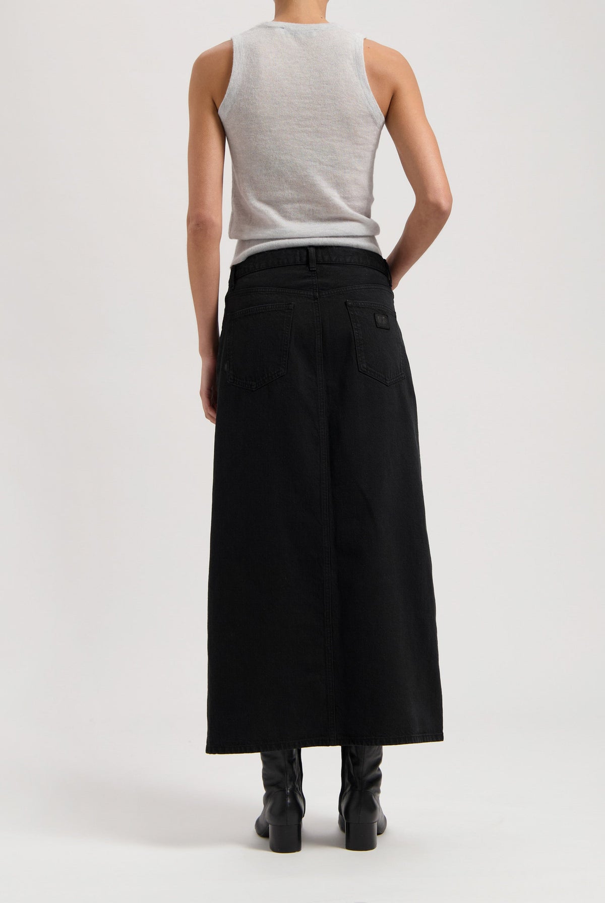 Sleeveless gray top with long black denim maxi skirt, showcasing back style with visible stitching and belt loops.