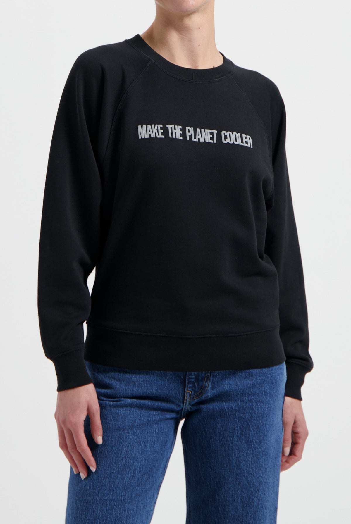 Black sweatshirt with "Make the Planet Cooler" text, paired with blue denim jeans, eco-friendly casual fashion style.