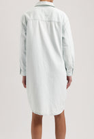 Back view of a light blue denim shirt dress showing a relaxed fit with long sleeves and classic collar design.