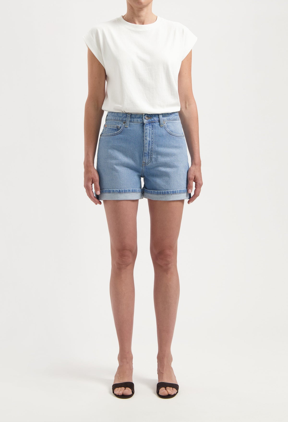 Light blue denim shorts paired with a casual white sleeveless top and black open-toe sandals for a fresh summer look.
